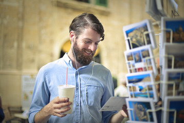 Handsome man choosing a postcard