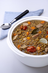 Pot of lentils with meat and white background