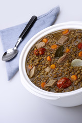 Pot of lentils with meat and white background
