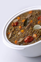 Pot of lentils with meat and white background
