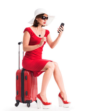 girl with telephone sitting on suitcase