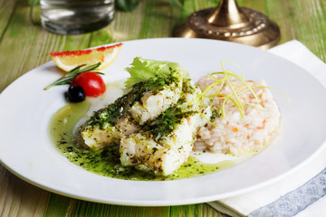 white fish with pesto sauce and meat plate in a still life