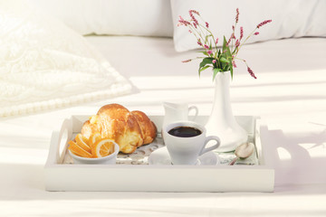 breakfast on wooden tray on the bed
