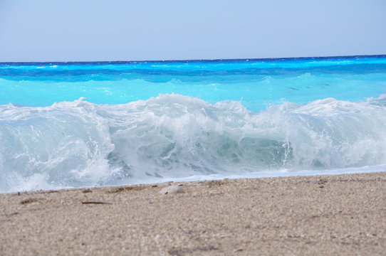 Fototapeta Waves on a sandy beach and a fairytale blue water