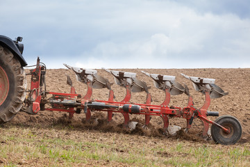 Detail of an agricultural  plough in action ploughing an overwintered fallow field ready for the planting of the spring crops