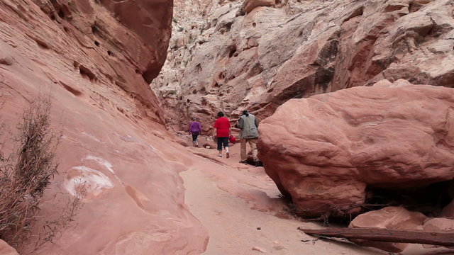 Friends climbing hike through steep rock slot canyon Utah HD 1614