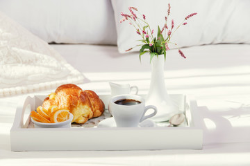 breakfast on wooden tray on the bed