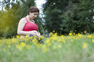 Pregnant woman sitting and relaxing outdoors