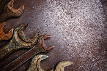 Old rusty wrenches on a metal table