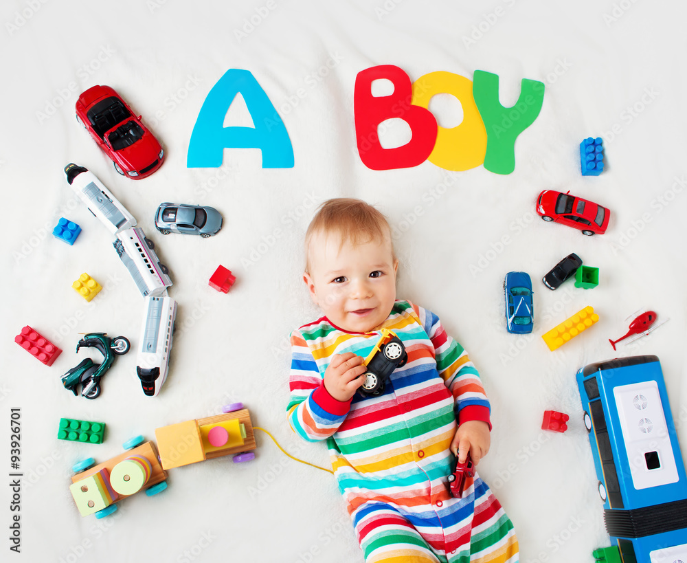 Wall mural Baby boy lying on the blanket with letters above