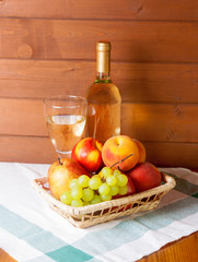 Fruits, wineglass and bottle with wine on a table