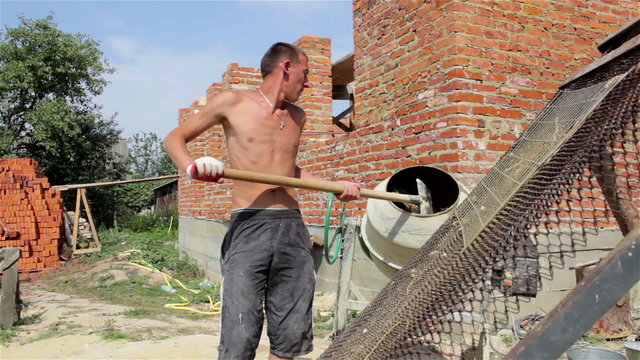 man makes concrete/Man concrete mixer knead sypet shovel sand in concrete inside