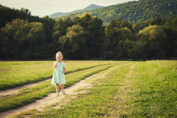 Adorable little girl on a sun covered meadow