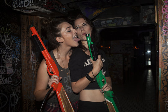 Young women playing with plastic guns