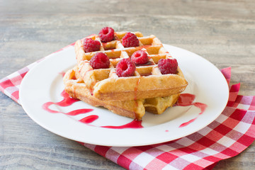 Waffles with raspberries and strawberry syrup