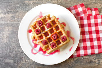 Waffles with raspberries and strawberry syrup