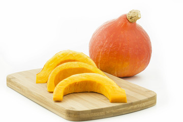 Ganzer Hokaido Kürbis und Stücke auf Holzbrettchen