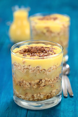 Simple no-bake Danish apple cake called Aeblekage made of stewed apple and vanilla cookie crumbs, with custard and chocolate on top (Selective Focus, Focus one third into the chocolate on the top)