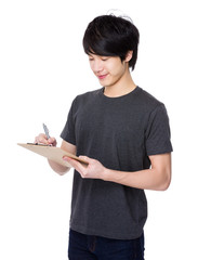 Young Man write on clipboard