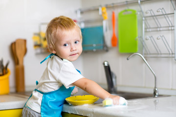 Child washing dishes in a domestic kitchen