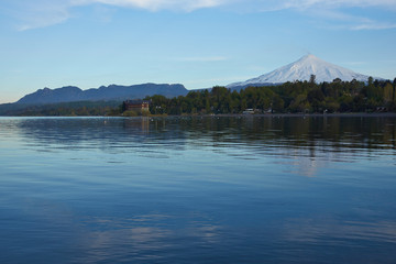 Snow capped cone of Villarrica Volcano (2,860m) rising above Lake Villarrica in the lake district...