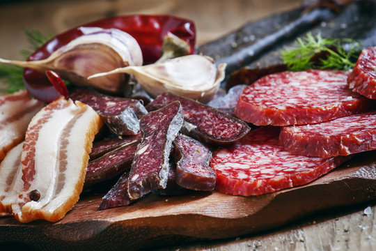 Meat appetizer platter with bacon, smoked sausage and salami on