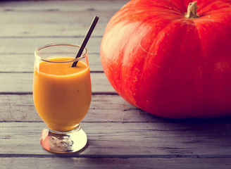 Healthy pumpkin smoothies with spices and nuts on rustic  table