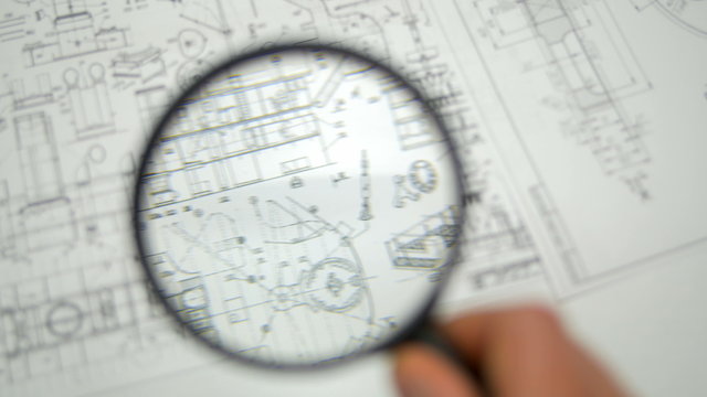 The look through loupe (magnifier) at blueprints engineering project