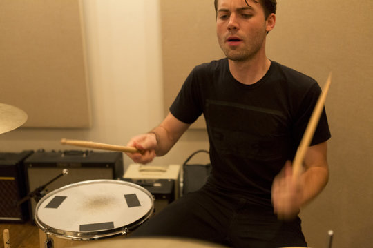 Young man drumming during a band rehearsal