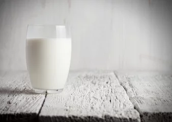Crédence de cuisine en verre imprimé Produits laitiers Glass of milk standing on old wooden table