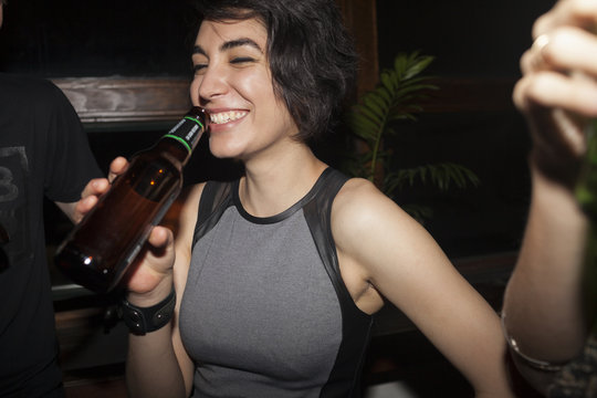 Young woman enjoying a beer at a party