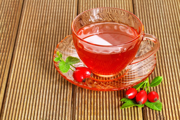 rose hip tea with fresh berries on the wooden background