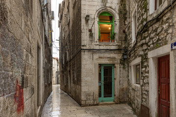 Fototapeta na wymiar Narrow and empty alley or pedestrian street at the Diocletian'S Palance in Split, Croatia.