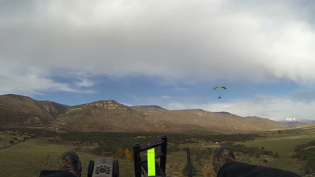 Aerial shot ultralight powered parachute fly towards mountain HD 0186
