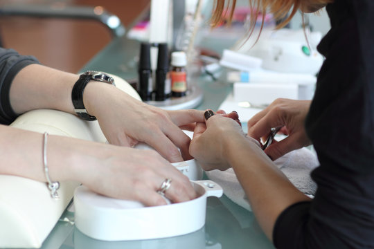 Woman in nail salon receiving manicure by beautician. Woman getting manicure at beauty salon 