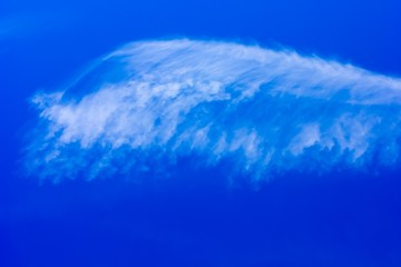 beautiful cirrus cloud in the form of a sea wave on a blue sky