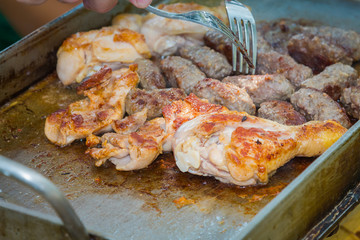 Checking the readiness of grilled chicken and kebab.