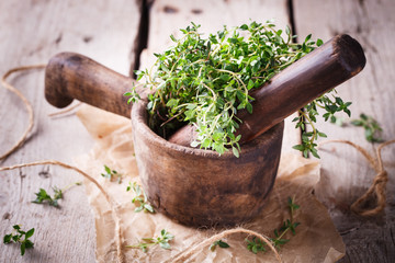 Wooden mortar with thyme. Vintage mortar made of solid wood.