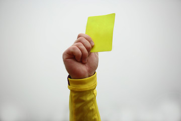 Hand  holding up yellow card