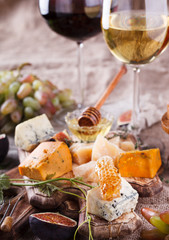 Grape, cheese, figs and honey with a glasses of red and white wine.Cheese Board.selective focus