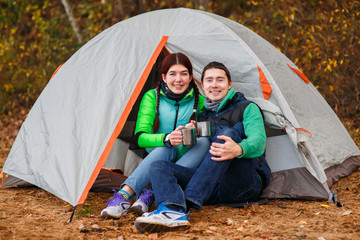 woman and man sitting near tent