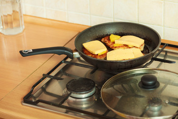 Frying chicken cutlet with pineapples and cheese.