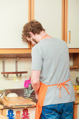 man doing the washing up in kitchen