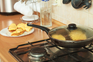 Frying chicken cutlet with pineapples and cheese.