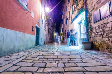 Narrow street in night of old town of Rovinj, Croatia