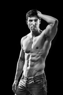 balck and white photo of muscular torso of man on black bakground