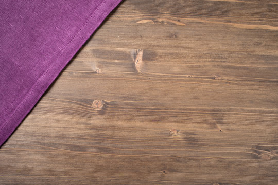 Purple  napkin from left top corner wooden table