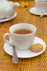 Cup of tea spoon and cookies on saucer