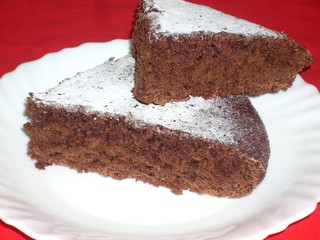 Chocolate cake with nuts and rum impregnating, dusted with icing sugar