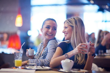 girls have cup of coffee in restaurant